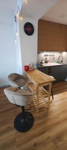 a kitchen with a wooden table and a stool at Studio Na náměstí in Potštát