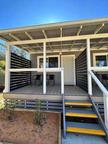 a screened in porch of a house with two chairs at Hay Caravan Park in Hay