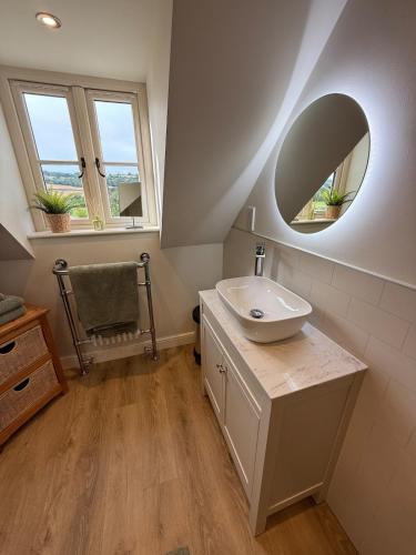 a bathroom with a sink and a mirror at Minafon Loft in Meifod