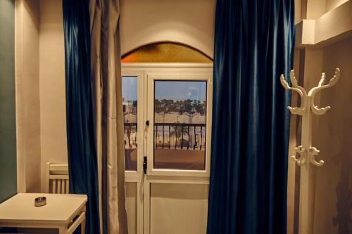 a room with blue curtains and a window with a view at Town Hotel- Hurghada in Hurghada
