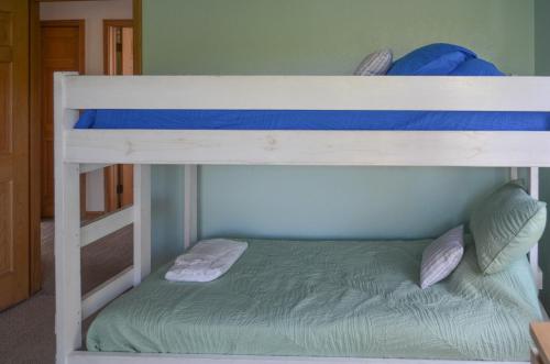 two bunk beds in a room with a green bed at Whalers Inn - C7928 in Corolla