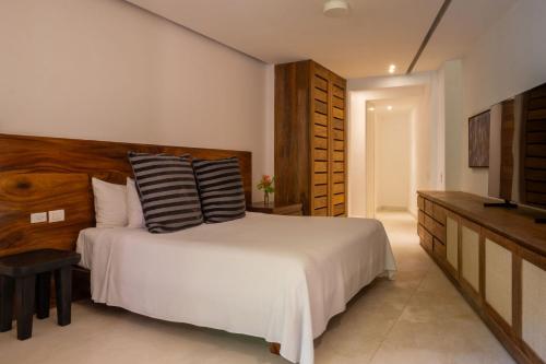 a bedroom with a white bed and a television at El Careyes Club & Residences in Careyes