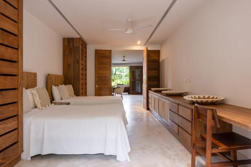 a bedroom with two white beds and a wooden counter at El Careyes Club & Residences in Careyes