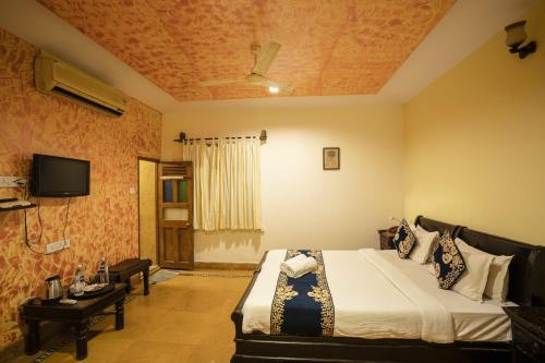 a bedroom with a bed and a tv in it at Jaisalmer Elite Castle in Jaisalmer