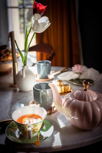 a table with a tea pot and a vase with a flower at Number 59 Dublin in Dublin