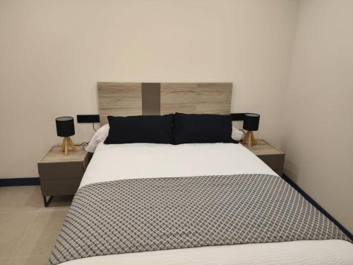 a bedroom with a large bed with two night stands at Vivienda Unifamiliar Ventana a la Clerecía in Salamanca