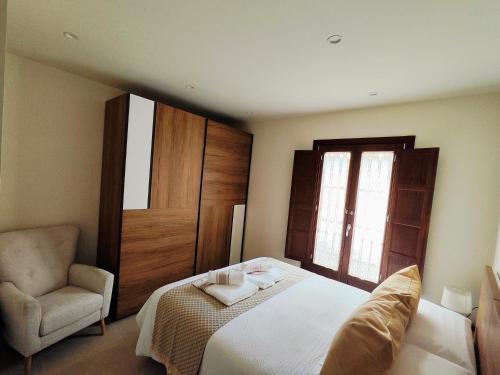 Vivienda Unifamiliar Ventana a la Clerecía في سلامنكا: غرفة نوم بسرير ابيض وكرسي