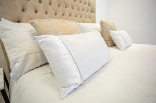 Una cama blanca con almohadas blancas. en Ocean Seven, en Harare