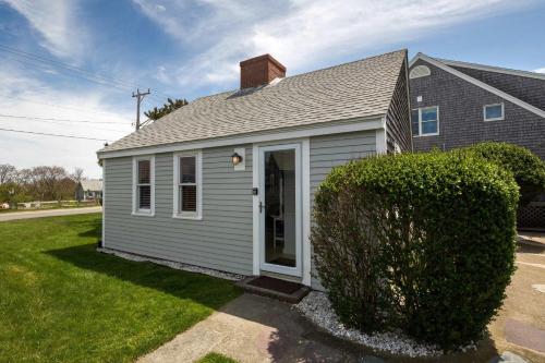 a small grey house with a hedge at Charming Beachside Bungalow in Truro