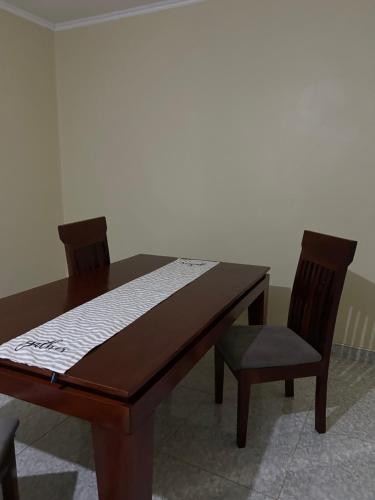 Una mesa de madera y una silla con un colchón encima. en Mable Home, en Mzuzu