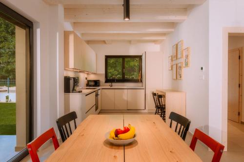 a kitchen with a wooden table with a bowl of fruit on it at BINDT chalets in Hnilčík