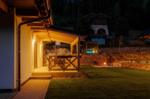 a patio with a table in a yard at night at BINDT chalets in Hnilčík