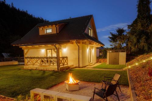 a small house with a fire in the yard at BINDT chalets in Hnilčík