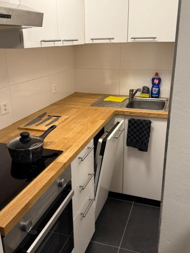 a kitchen with white cabinets and a wooden counter top at 1 room apartment in Canton Zug in Unterägeri