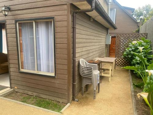 a patio with a table and chairs next to a house at Cabañas Santa María in Pichilemu