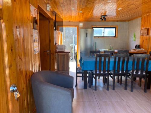 a dining room with a blue table and chairs at Cabañas Santa María in Pichilemu
