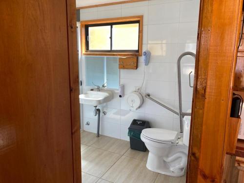 a small bathroom with a toilet and a sink at Cabañas Santa María in Pichilemu