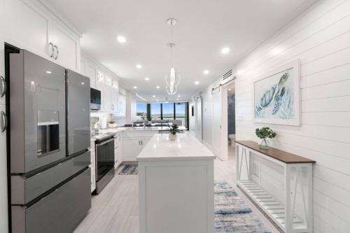 a kitchen with white cabinets and a black refrigerator at Riverside Club A209 in Marco Island
