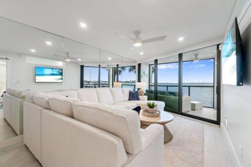 a living room with white furniture and large windows at Riverside Club A209 in Marco Island