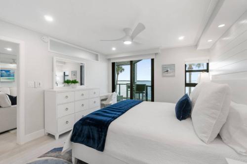 a white bedroom with a large bed and a window at Riverside Club A209 in Marco Island