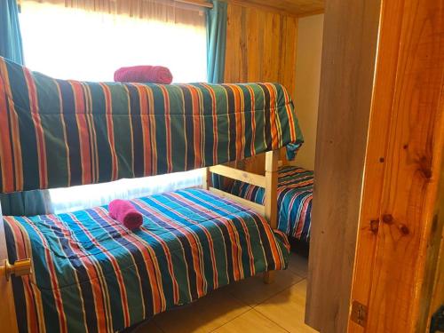 a room with two bunk beds and a window at Cabañas Santa María in Pichilemu