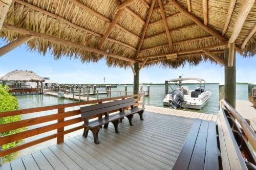 a dock with a bench and a boat on the water at Riverside Club A209 in Marco Island
