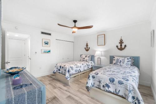 une chambre avec deux lits et un ventilateur de plafond dans l'établissement Surfside Escape, à Marco Island