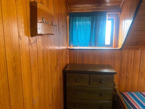 a bedroom with a bed and a window and a dresser at Cabañas Santa María in Pichilemu