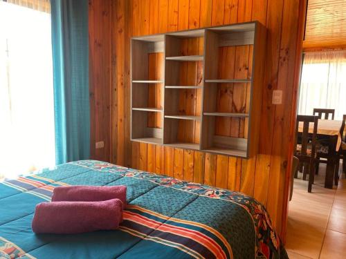a bedroom with a bed and a book shelf at Cabañas Santa María in Pichilemu