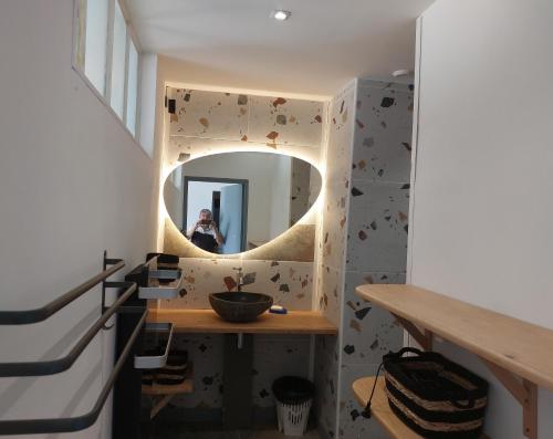 una mujer tomando una foto de un espejo en un baño en Gite du Château le Mas, en Saint-Laurent-des-Hommes