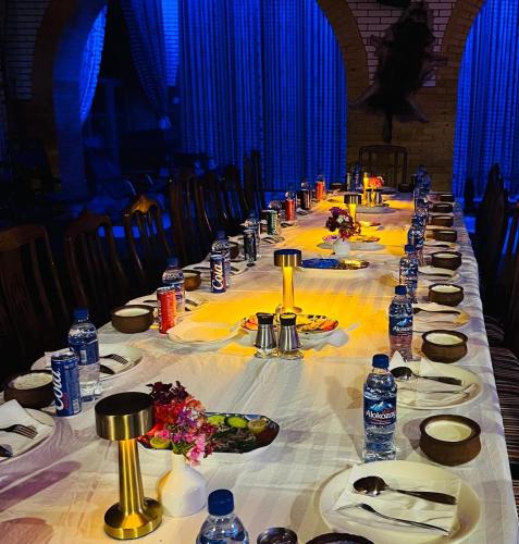 a long table with plates of food and water bottles at Kabul Qargha Palace Hotel, Restaurant and wedding Hall in Kabul