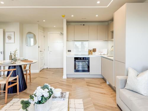 a kitchen and living room with a couch and a table at Dorchester Centre Apartment - Free Parking & Views in Dorchester