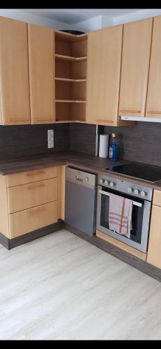 a kitchen with wooden cabinets and a stove top oven at Knusperhäuschen in der Natur in Ardning