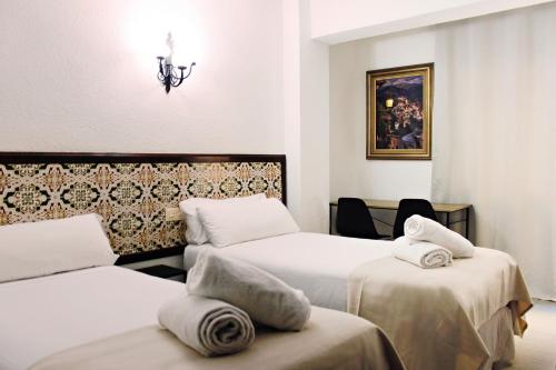 a hotel room with two beds with towels on them at Pensión Eurosol in Granada