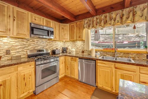 a kitchen with wooden cabinets and stainless steel appliances at Game Room and 2 Decks Walkable Lake Arrowhead Cabin in Lake Arrowhead