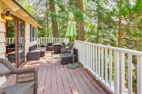 a porch with chairs and an umbrella on a house at Game Room and 2 Decks Walkable Lake Arrowhead Cabin in Lake Arrowhead