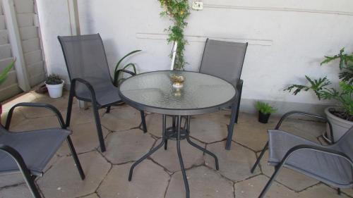 a table and chairs in a patio with plants at The Falcon in Windhoek