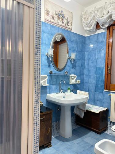 a blue tiled bathroom with a sink and a shower at La Casa al Sole in Mazara del Vallo