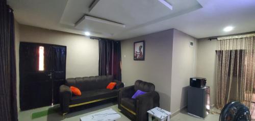a living room with a couch and a television at 2 bedroom service apartment in Ibadan
