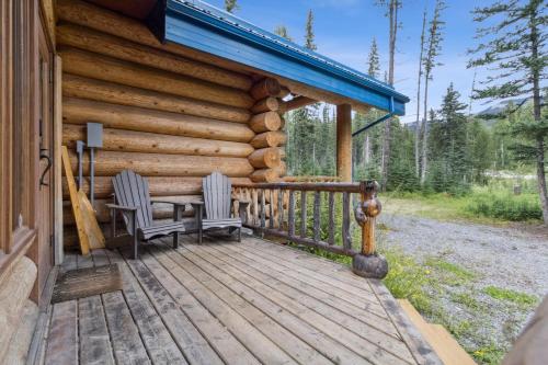 a cabin with two chairs on a wooden deck at Nordegg Timber Estate in Nordegg