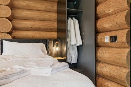 a bedroom with a bed and a wooden wall at Nordegg Timber Estate in Nordegg