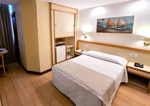 a hotel room with a bed and two tables at Riale Imperial Flamengo in Rio de Janeiro