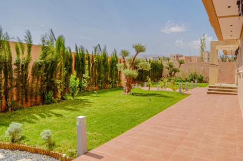 a garden with grass and trees and a brick walkway at Perfect Stop in Midelt in Midelt
