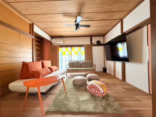 a living room with a couch and a television at Vintage House Cortile of HIMAWARI in Matsudo