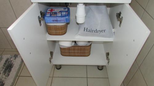 a white cabinet with a sink in a bathroom at The Falcon in Windhoek