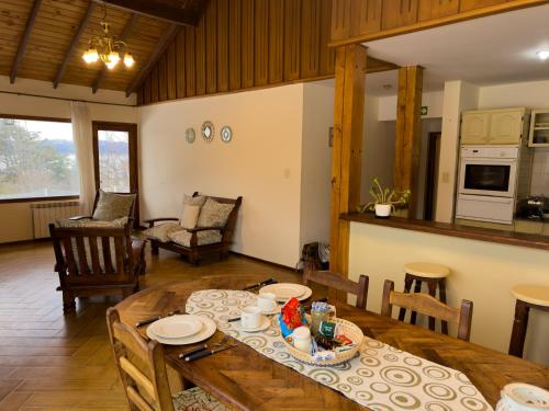 sala de estar con mesa de madera y cocina en CASA WAIA ULU, en Ushuaia
