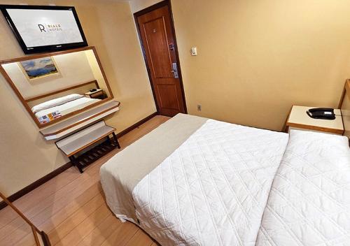 a hotel room with a bed and a flat screen tv at Riale Imperial Flamengo in Rio de Janeiro