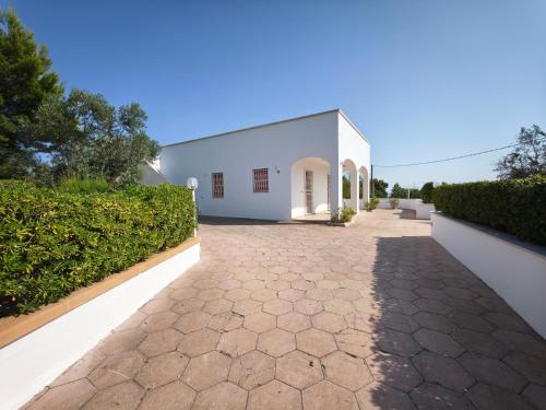 un edificio blanco con un camino delante de él en Villa Pesce, en Torre Pali