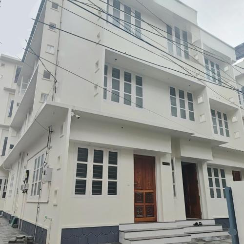 a white building with two doors on it at Sivasarass rooms in Trivandrum
