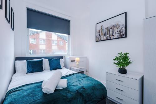 a bedroom with a large bed and a window at FREE parking, LARGE House for Contractors & Families, Sleeps 10, 25 mins to ALTON TOWERS in Stoke on Trent